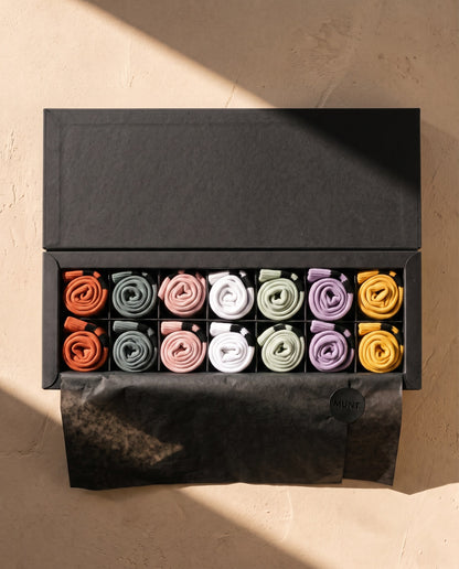 The Full Week by MUNT: the open case, seven pairs in order under black tissue with the MUNT seal.
