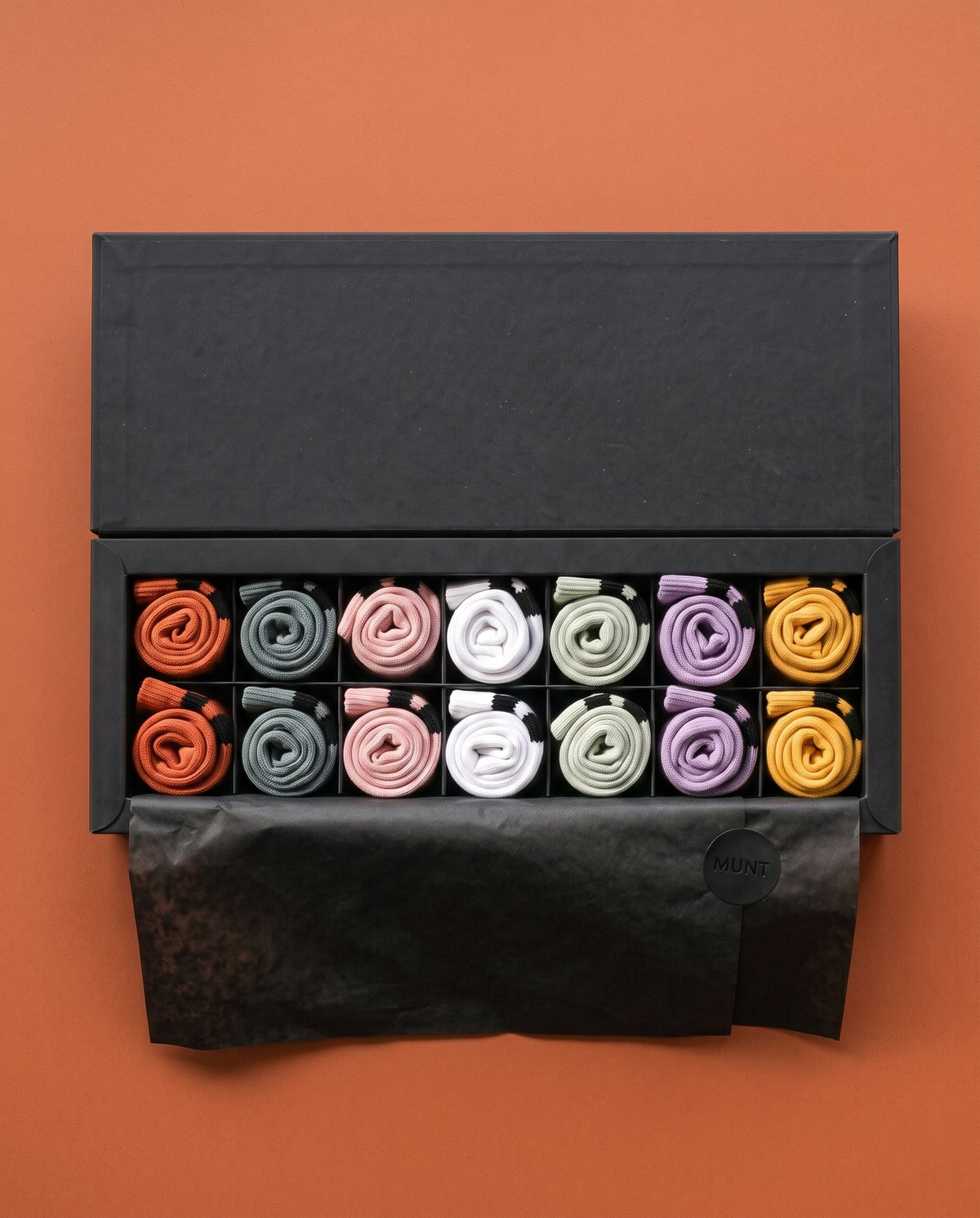 The tissue folded back: seven pairs in fourteen compartments, Monday to Sunday.